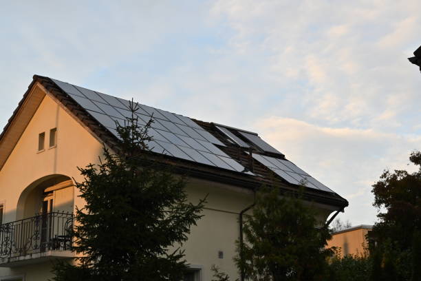Solar panels or photovoltaic panels installed on the roof of a family house observed during sunset.